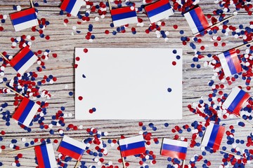 the independence day of Russia. June 12 . the concept of patriotism, freedom and independence. mini flags with red white blue and confetti white card on wooden background