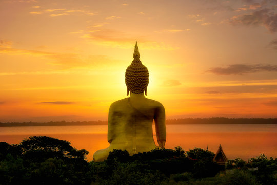 Big Buddha image by the river, near the sunset in Thailand.
