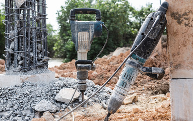 Jackhammer stand vertically at bridge construction site repair.
