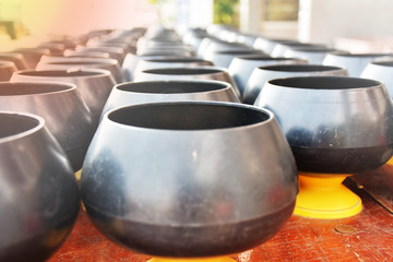 Many mini monk's alms bowls are arrange in line for receive coin from people make merit by donation.