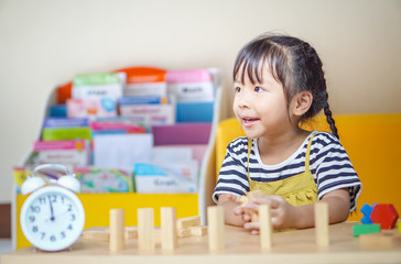 happiness little girl learning construction with wooden blocks or wood blocks stack game. concept education.