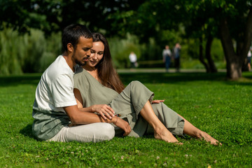 Happy mixed love couple hugging in park on background greenery. hot summer sunny weather. friend and girlfriend different nationalities love each other. Tolerance, Lifestyle