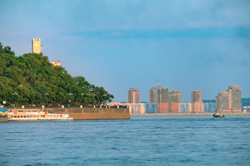 Fototapeta premium View of the city of Khabarovsk from the Amur river. Urban landscape in the evening at sunset.