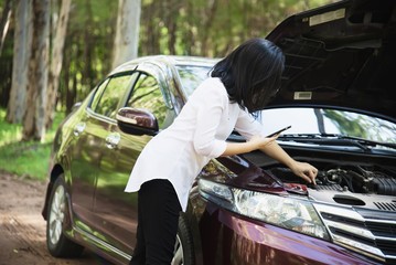 Asian woman calling repairman or insurance staff to fix a car engine problem on a local road - people with car problem transportation concept