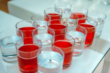 A row of glasses filled with cold champagne lined up, ready to be served. Glasses with Martini on the table - party background. Welcome drink on the wedding ceremony.