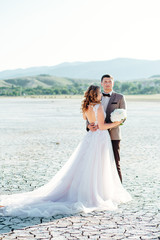 Happy newlywed couple. Beautiful bride and groom in a suit.