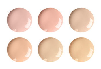 Set with smears of different foundations on white background