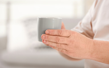 Closeup view of elderly man with cup of tea in nursing home, space for text. Assisting senior generation