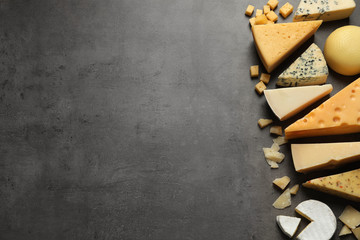 Different delicious cheeses on grey table, top view. Space for text