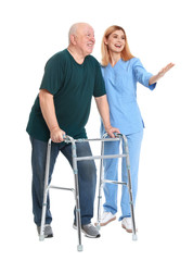 Caretaker helping elderly man with walking frame on white background