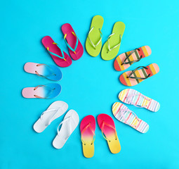 Flat lay composition with different flip flops on blue background, space for text. Summer beach accessories