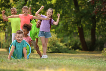 Fototapeta premium Cute little child playing with friends in park, space for text