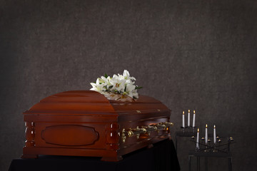 Wooden casket with white lilies in funeral home - obrazy, fototapety, plakaty