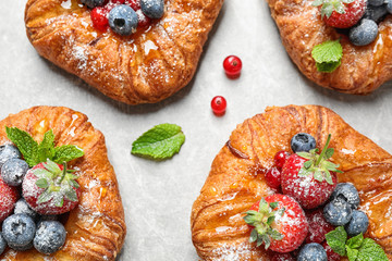 Fresh delicious puff pastry with sweet berries on light background, flat lay