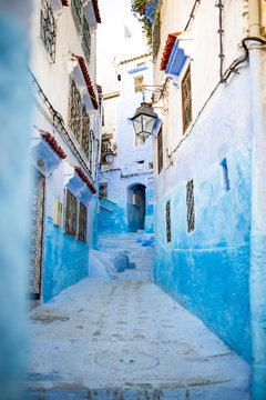 Stunning view of a narrow alleyway with the striking, blue-washed buildings. Chefchaouen, or Chaouen, is a city in the Rif Mountains of northwest Morocco.