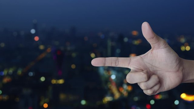 Map pin point location button on finger over blur colorful night light city tower and skyscraper, Technology map pointer navigation online concept