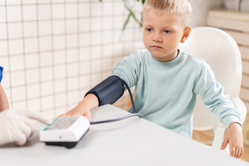 Doctor measuring blood pressure of a little boy. Diagnostic, healthcare, medical service. Doctor...