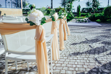 White wedding chairs with flowers on weddind
