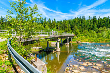 Bridge on Dunajec river on sunny summer day near Nowy Targ, Tatra Mountains, Poland