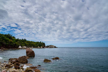 Montenegro, Alone at remote rocky beach near budva in summer holiday for relaxing under blue sky with clouds