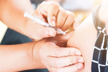 Medical hand giving patient flu shot vaccine and influenza immune prevention disease.Concept nurse syringe needle hypodermic injection.drug insulin,hepatitis vaccination.hospital.selective focus.