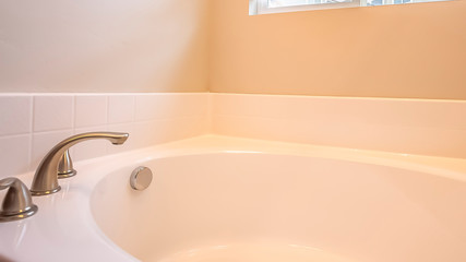 Panorama Bathroom interior with gleaming white oval bathtub and stainless steel faucet