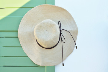 Straw hat hanging on wooden door