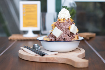 Snow ice cream cocoa dessert with milk sauce, bread, corn flake and whip cream topping.Traditional ice cream in Thai style sweet dessert