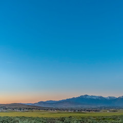 Square Scenic panoramic view of the valley lake and snow peaked mountain under blue sky