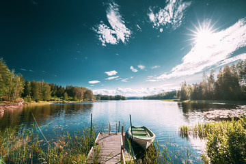 Old Wooden Fishing Boat Moored Near Pier In Summer Lake Or River. Beautiful Summer Sunny Day Or Evening. Swedish Nature. Arjang SV, Tocksfors, Sweden - obrazy, fototapety, plakaty