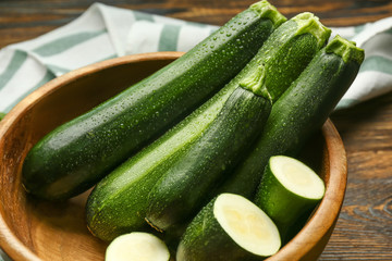 Bowl with fresh zucchini on table, closeup