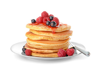 Plate with tasty pancakes and berries on white background