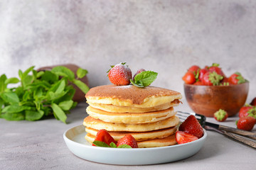 Plate with tasty pancakes and strawberry on table