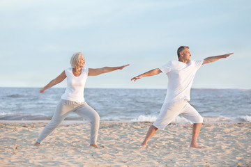 Mature couple training at sea resort