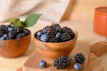 Tasty blackberries and blueberries on table
