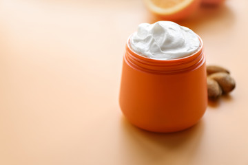 Jar of natural cream on color background