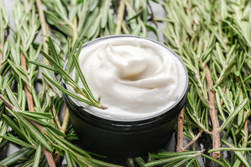 Jar of natural cream and rosemary branches on table