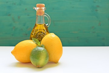 Concept with lemons, lime and a bottle of olive oil on blue and white background. Copy space, filter applied.