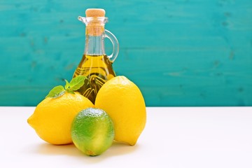 Concept with lemons, lime and a bottle of olive oil on blue and white background. Copy space