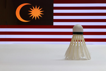 Used shuttlecocks on white floor with Malaysia flag background. Concept of Badminton.