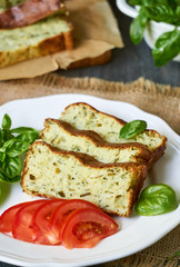 Casserole with zucchini, cheese and fresh herbs on a white plate