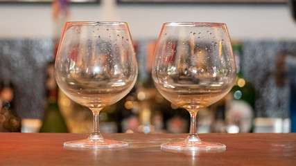 Two glasses of wine placed in front of the bar