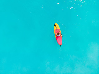 Woman relax on stand up paddle board on a quiet blue ocean