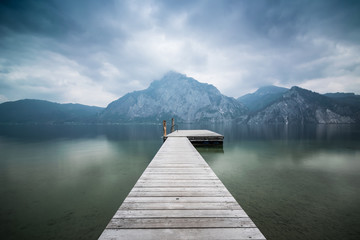 Fototapeta premium Steg am See in den Bergen - Wolken am Traunsee