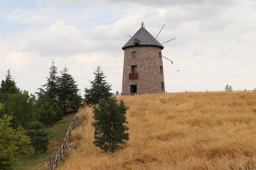 Fototapeta premium Old Wooden Windmill in the Field with Sky Background
