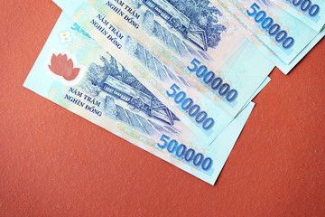 Obraz premium Five hundred thousand dong banknotes on a brown background close-up. Vietnamese money