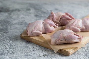 Raw uncooked quail. raw meat quails ready for cooking on a cutting board with copy space