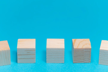 five wooden cubes on a blue background close-up front view, space for your text or advertising slogan