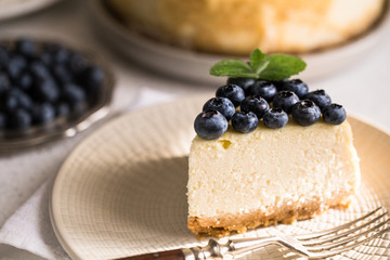 Slice Of Classical New York Cheesecake with blueberries On White Plate. Closeup View. Home bakery concept