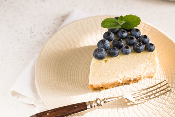 Slice Of Classical New York Cheesecake with blueberries On White Plate. Closeup View. Home bakery concept
